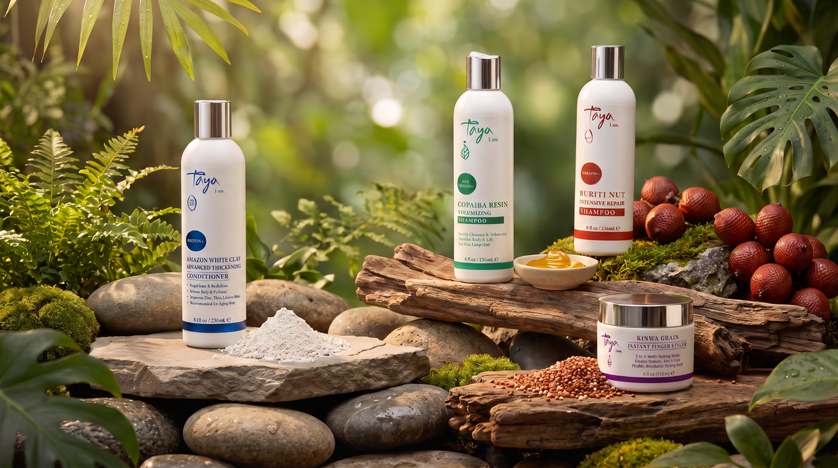 Four TAYA hair care products displayed beside white clay, copaiba resin, buriti fruits and kinwa grains in a warm rainforest setting